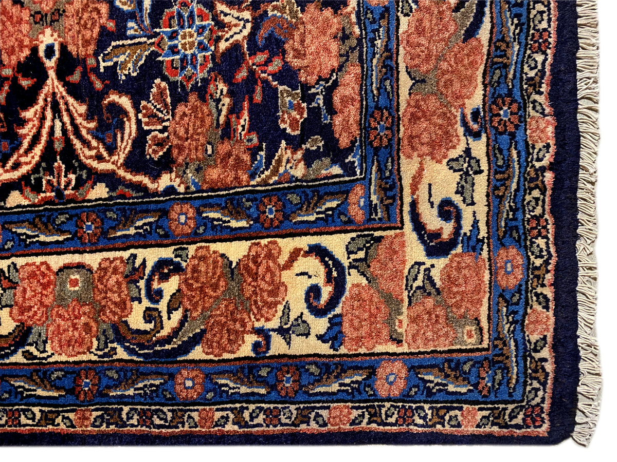 Carpet corner with fringe and a blue-red ornamental pattern, visible edge finish