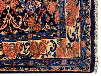 Carpet corner with fringe and a blue-red ornamental pattern, visible edge finish