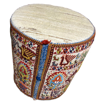 Round wool stool, side view, with a padded light-colored top
