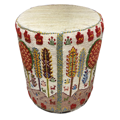 Colorful Soumak stool with a round seat and patterned upholstery, viewed from the front at an angle