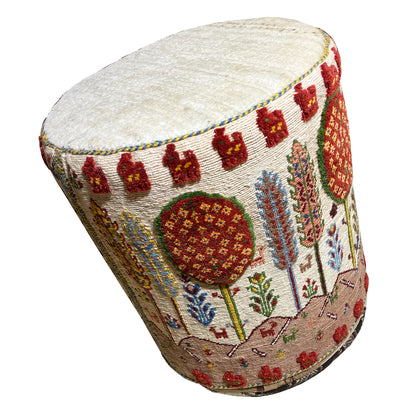 Colorful Soumak stool with round seat cushion and ornate cover, angled view