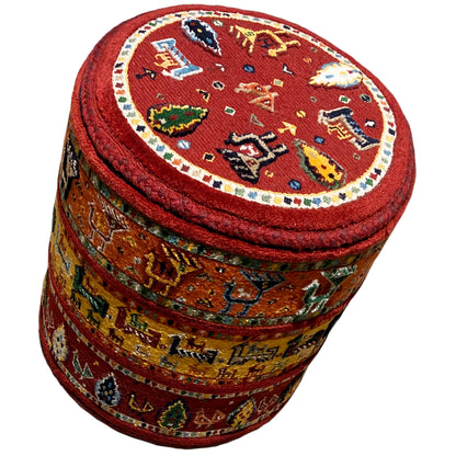 Round stool with a red seat, circular ring with Soumak motifs, and patterned sides