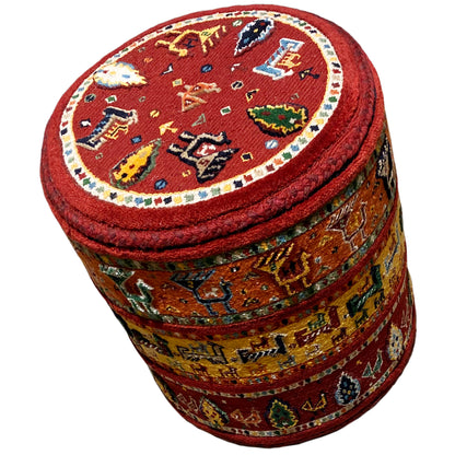 Stool with a red Soumak rug pattern, padded seat, and wide colorful bands