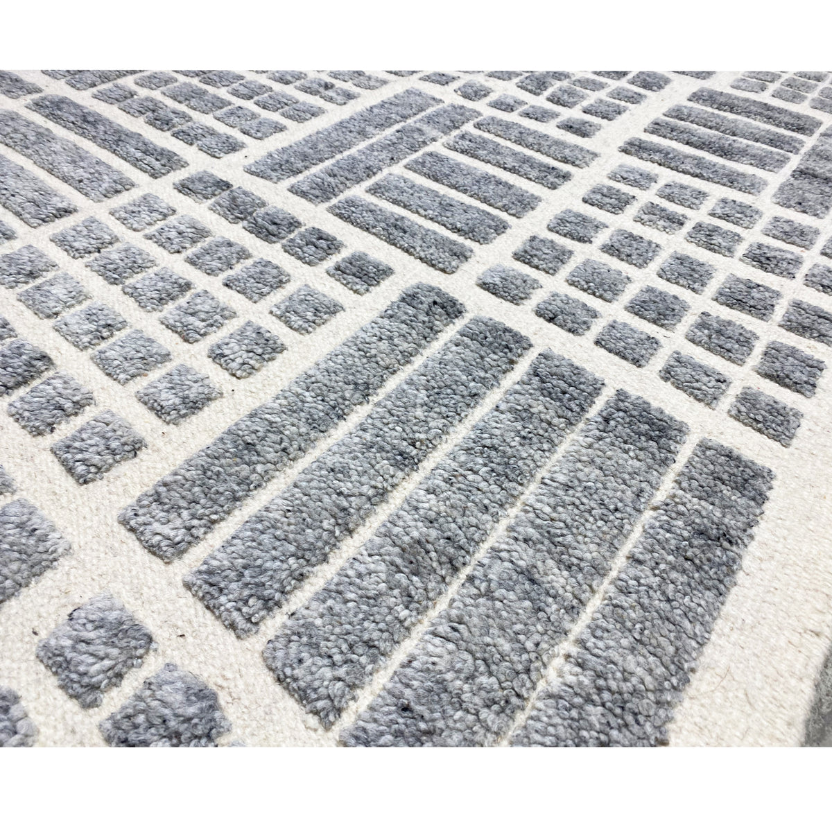 Detail view: gray-white geometry in the carpet weave, textured pile