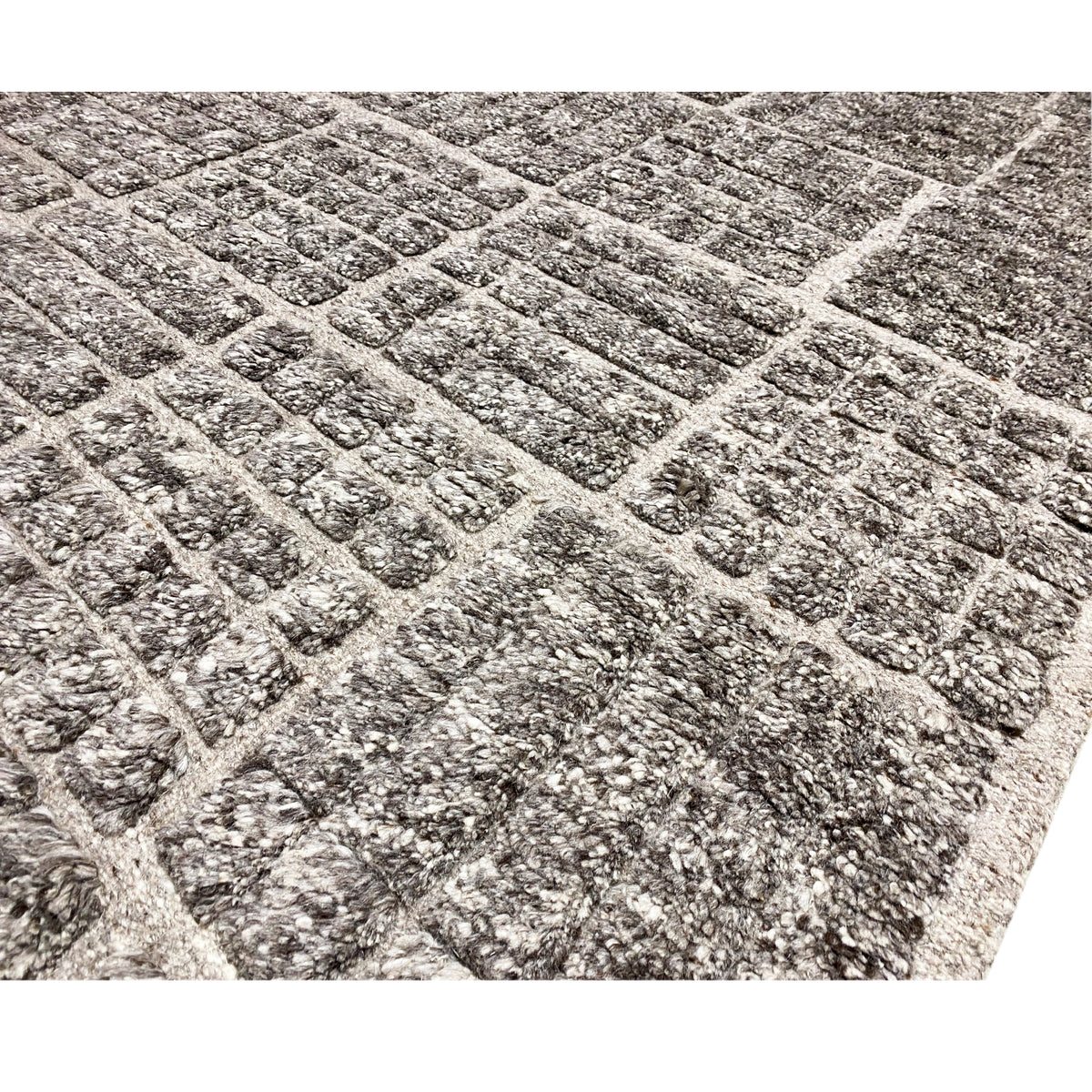 Close-up: Berber rug with a checkered grid in dark gray, mottled texture