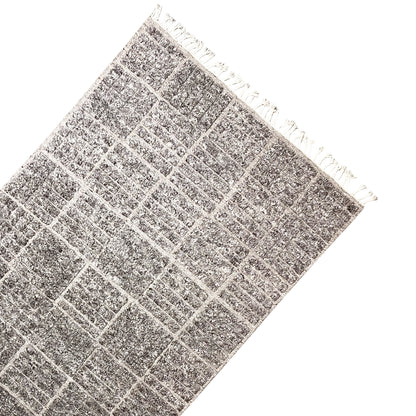 Berber rug corner with fringes, dark gray checked pattern, mottled texture