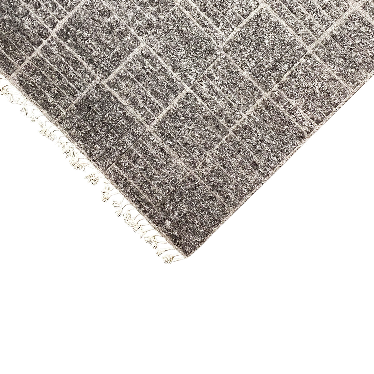 Corner in detail: dark check pattern, white fringes, mottled surface