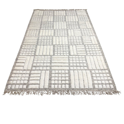 Berber rug with light gray and white patchwork design and fringes