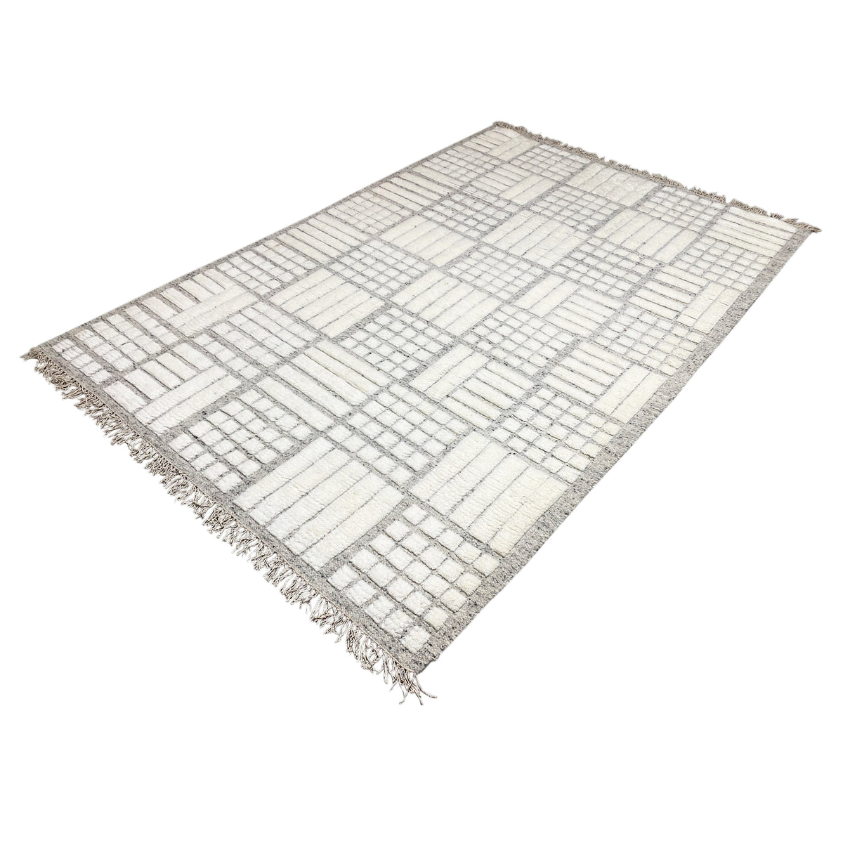 Rectangular Berber rug, light gray-and-white patchwork, fringes along the edges