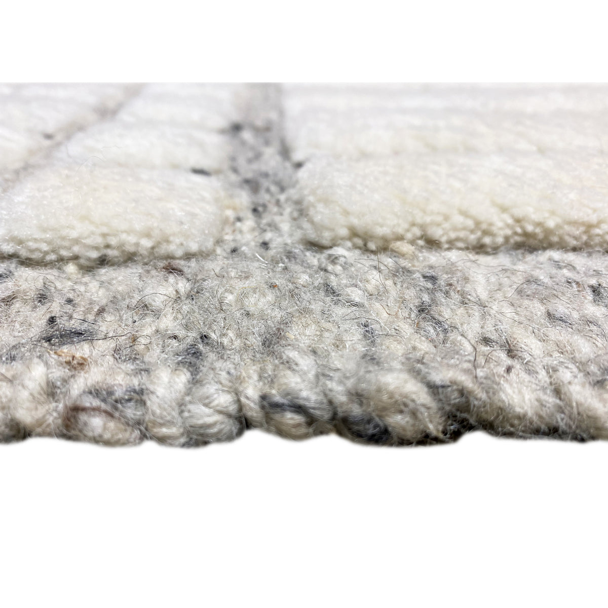 Close-up: White and gray short-pile rug edge, frayed