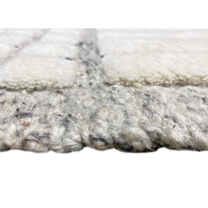 Close-up: White and gray short-pile rug edge, frayed