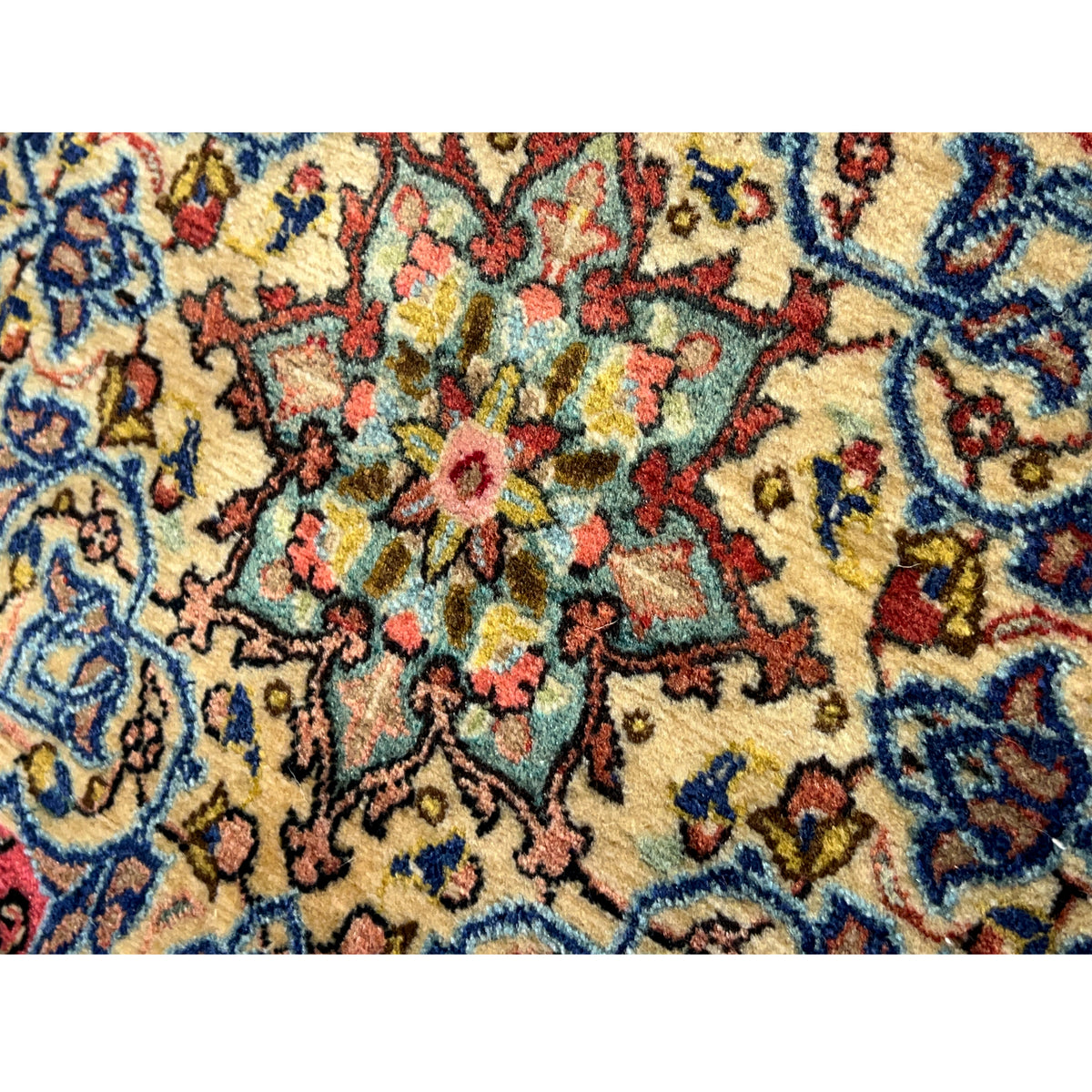 Close-up carpet texture: colorful ornamental pattern in blue, red, yellow, and green