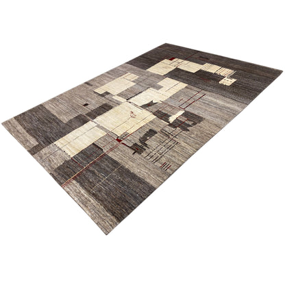 Gabbeh rug viewed from above at an angle, abstract patchwork in gray, beige, and red accents