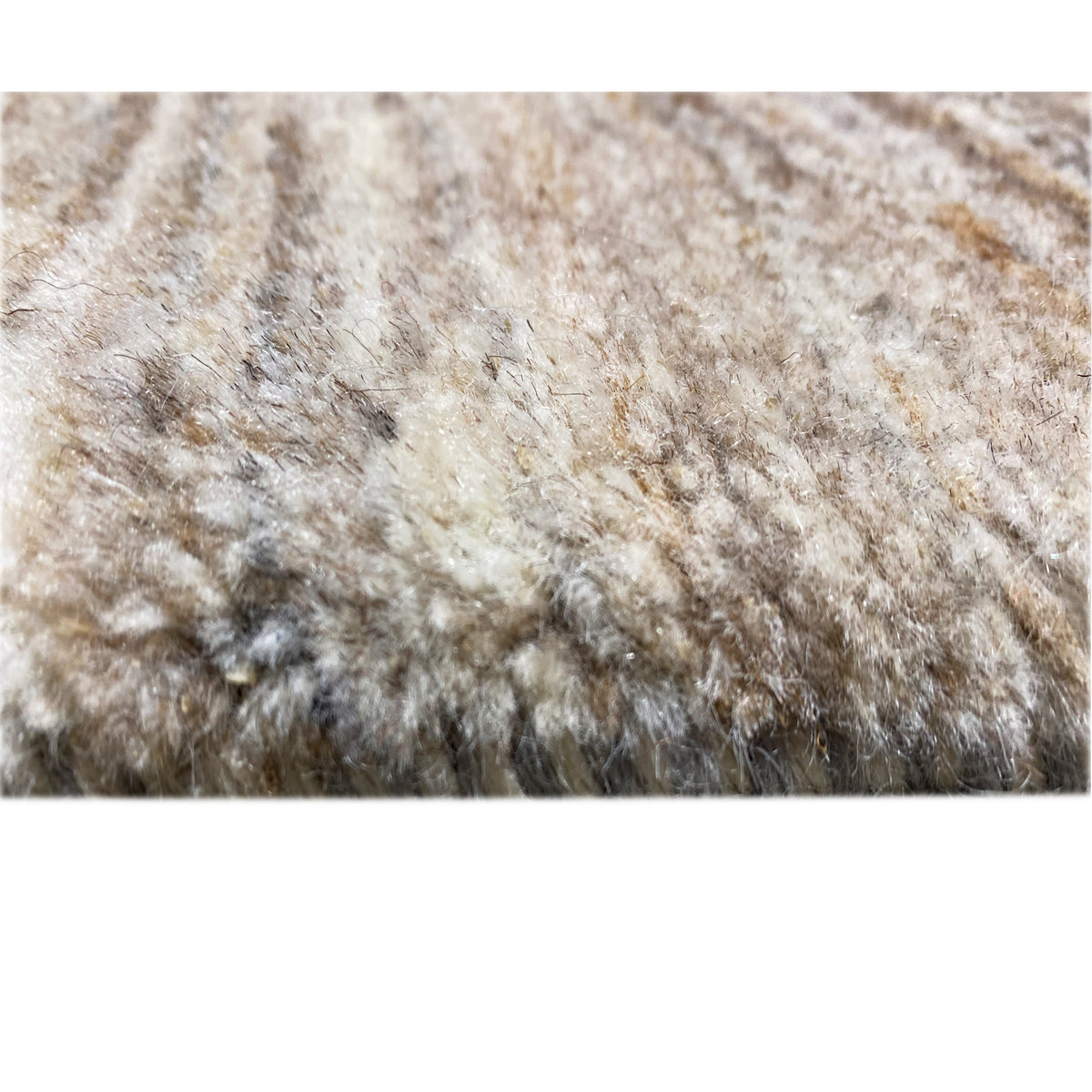 Rug pile detail: short, dense, plush pile in light beige and gray tones