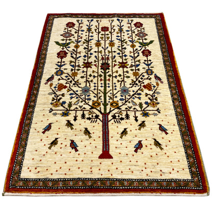Gabbeh rug with a beige background, red central tree, and multicolored border