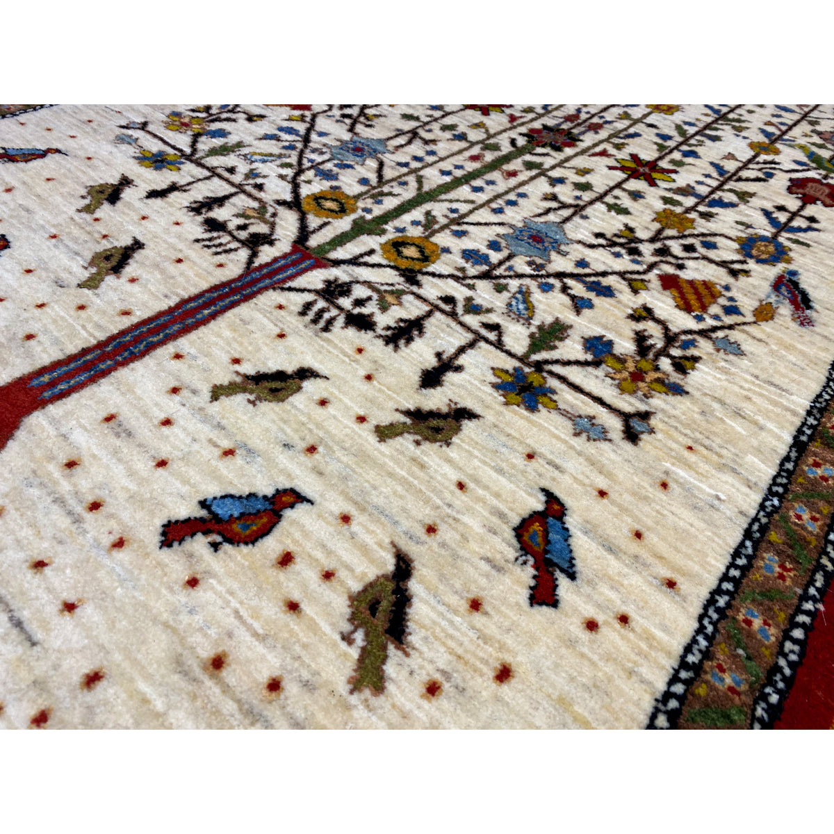 Close-up: Gabbeh rug with a beige pile and colorful small motif dots in the pattern