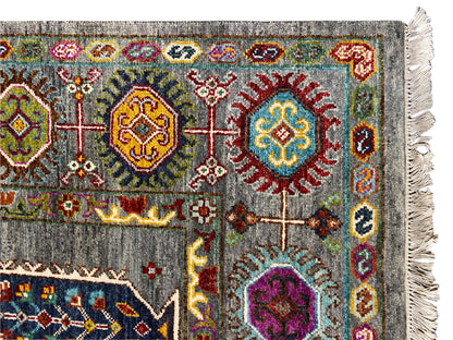 Teppich-Ecke: grauer Grund mit bunten Medaillons, Zierstreifen und Fransen.