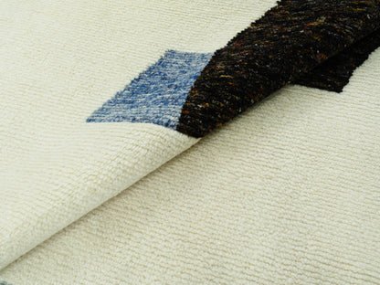 Teppich ausgebreitet: sichtbare Struktur und ein gerollter Bereich mit Blau-Schwarz-Element