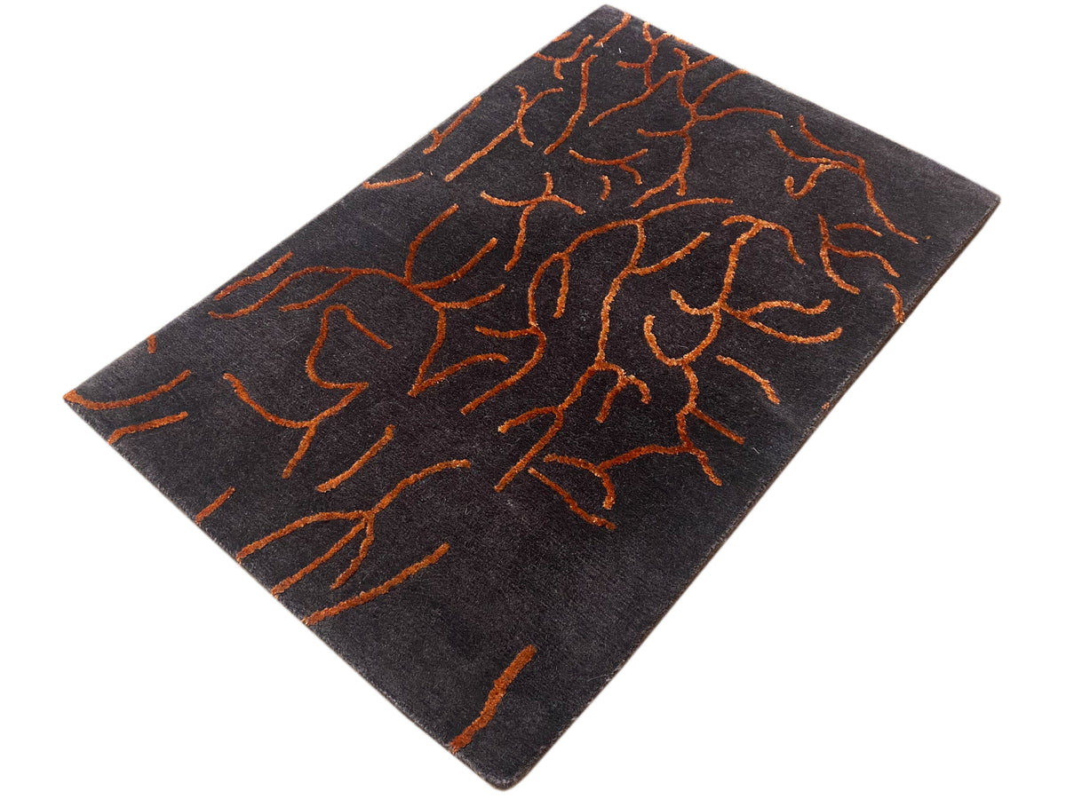 Dark gray designer rug with an abstract orange line pattern, rotated square