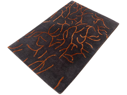 Dark gray designer rug with an abstract orange line pattern, rotated square