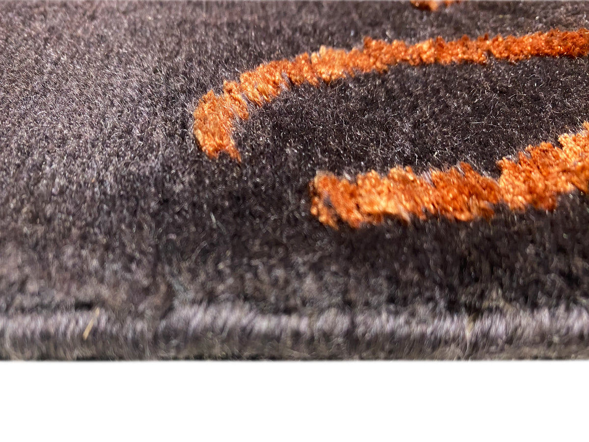 Carpet detail: dark gray pile with orange high-pile appliqués