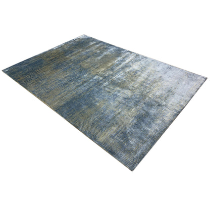 Designer rug with a blue-gray pattern and golden lines, spread out diagonally
