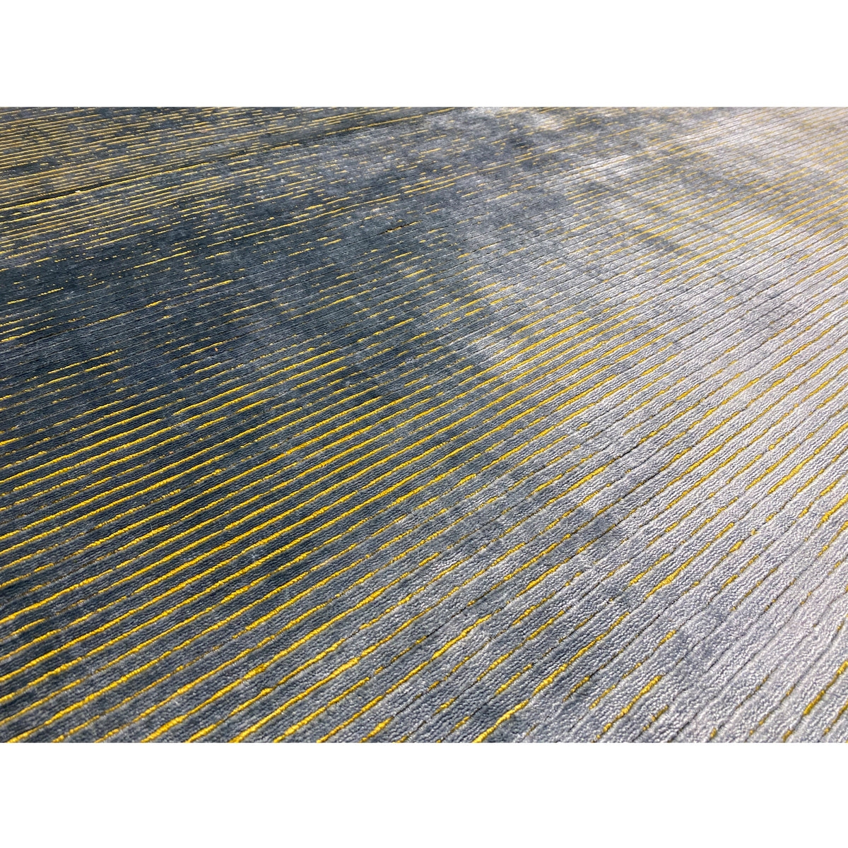 Designer rug detail: fine golden and gray-blue lines on a textured surface