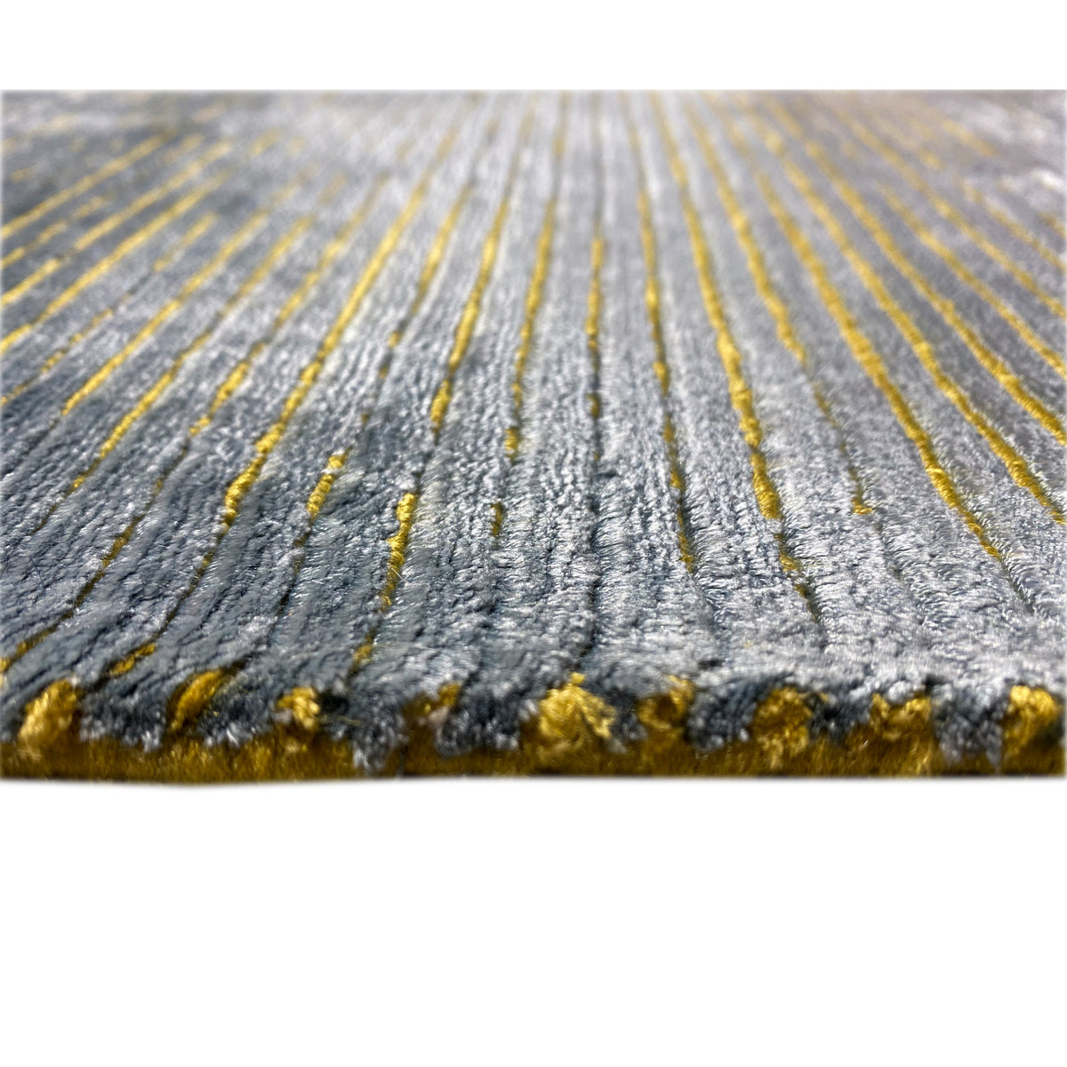 Designer rug edge detail: blue-gray fibers with golden accents