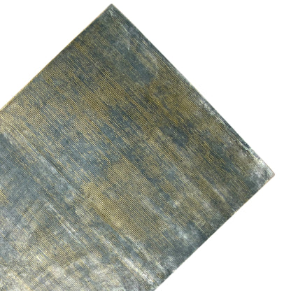 Designer rug up close: blue-gray mottled fabric with gold areas