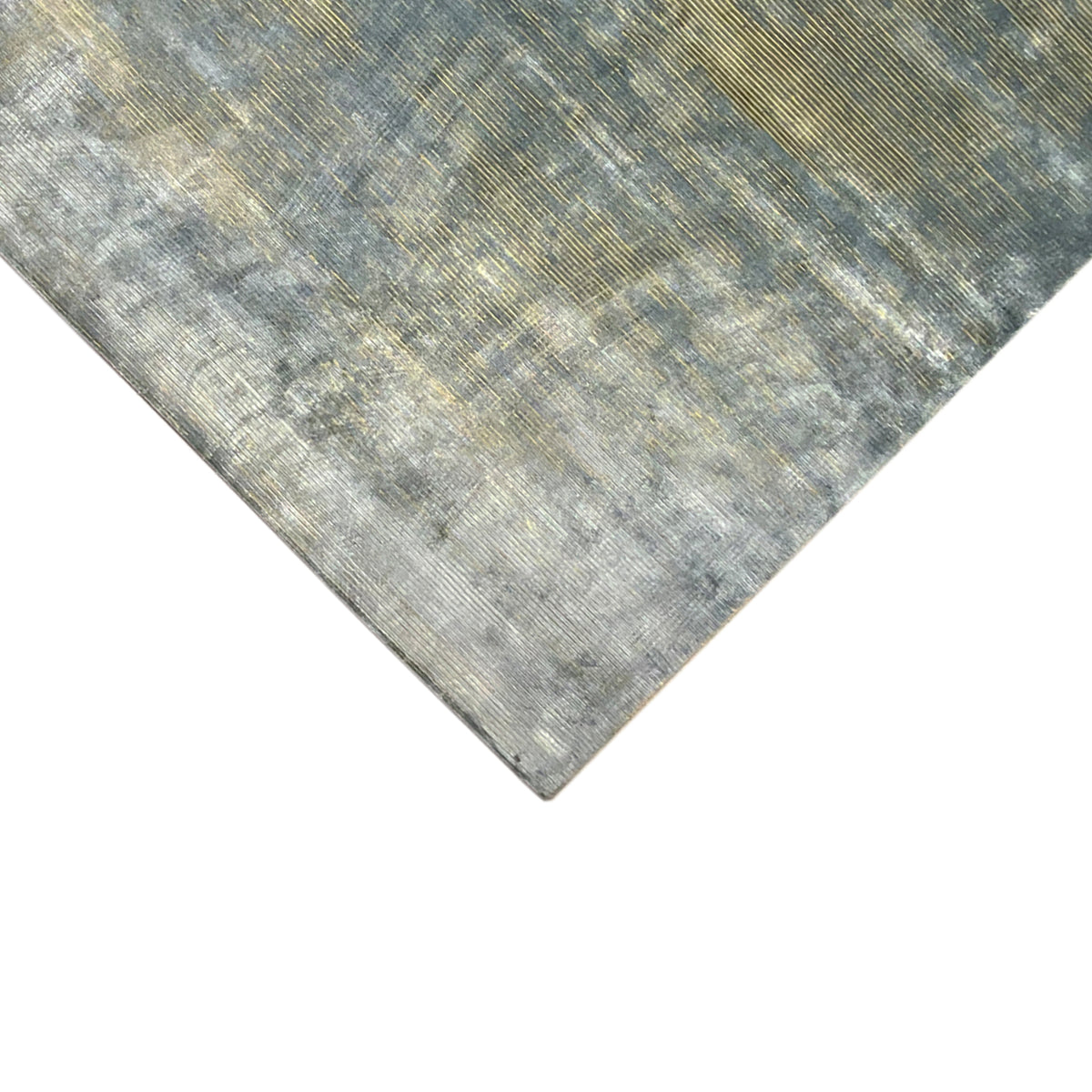 Close-up of the corner of a designer rug, mottled blue-gray with fine golden lines