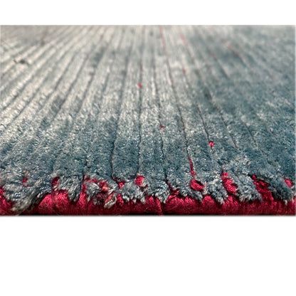 Designer rug detail with blue-gray pile and red border area