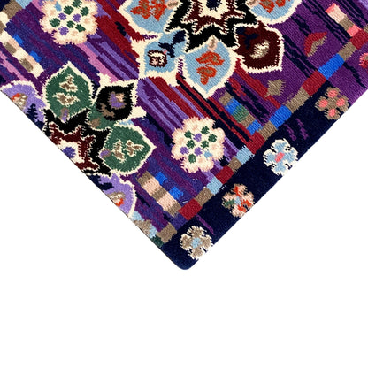 Rug 77x62 cm corner detail: colorful floral ornaments on a purple background