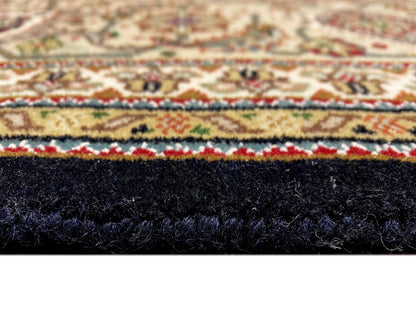 Indo Tabriz-Teppich: Nahaufnahme der Teppichkante mit dunklem Flor und mehrfarbiger Einfassung