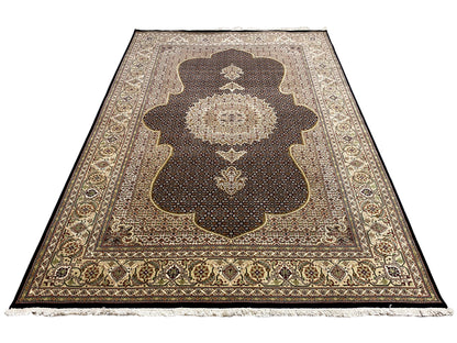 Teppich mit dunkelbraunem Grund, großem Zentralornament, beiger Bordüre und Fransen