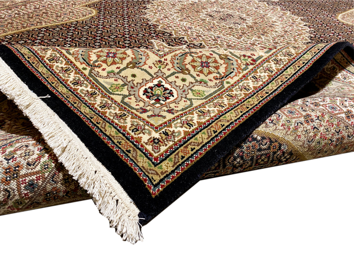 Teppich-Ecke mit weißen Fransen und mehrfarbigem Muster, dunkle Unterseite