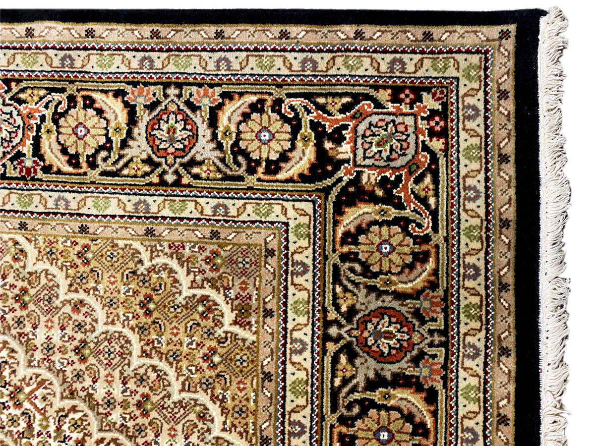 Teppichkante mit Fransen und mehrfarbiger Ornamentbordüre in Beige, Schwarz und Rot