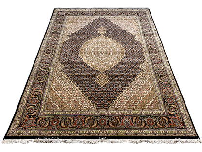 Rechteckiger Teppich mit beigem Mittelmedaillon, dunklem Musterteppich und Zierbordüre, Fransen.
