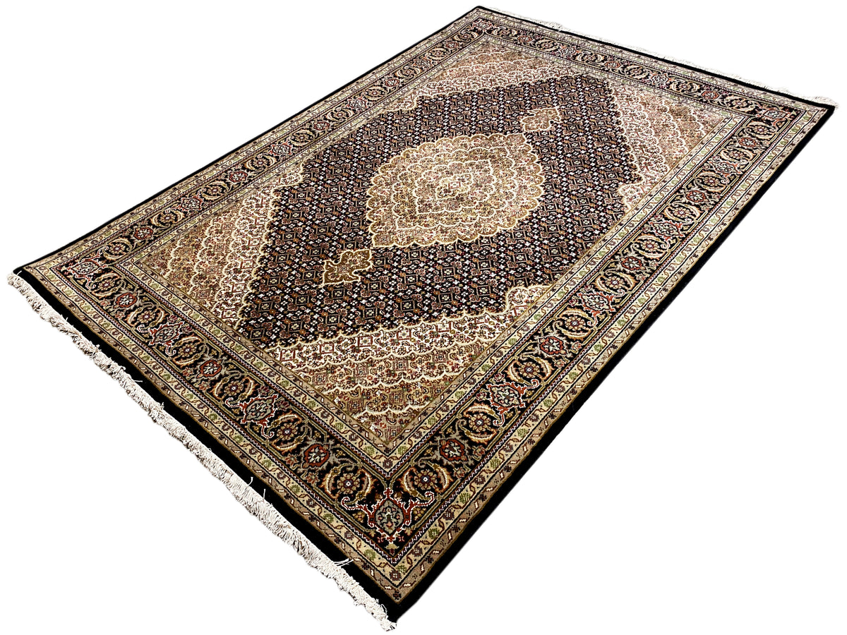Orientteppich im Schrägansicht, dunkles Feld mit hellem Medaillon und farbiger Bordüre