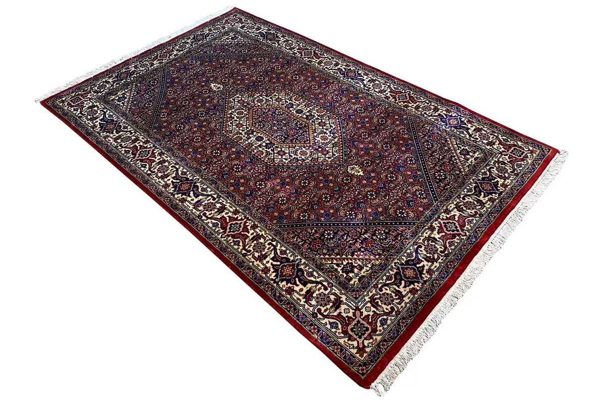Bidjar rug in diagonal view, dark red and blue with a fine ornamental border and fringes