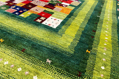 Gabbeh Lori rug detail view with a green border, colorful squares, and dotted decoration