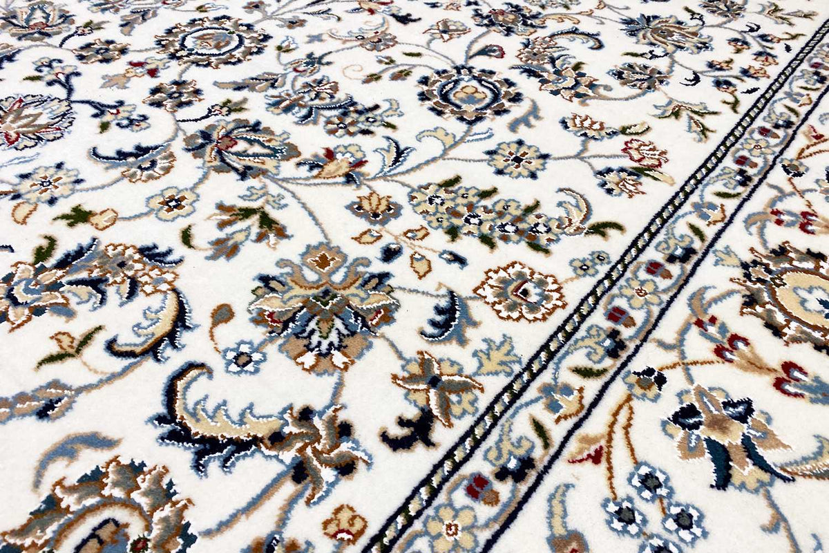 Close-up: beige carpet with a blue-and-beige floral motif and border detail