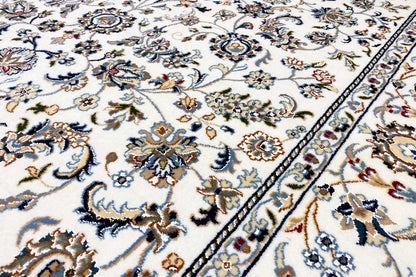Close-up: beige carpet with a blue-and-beige floral motif and border detail