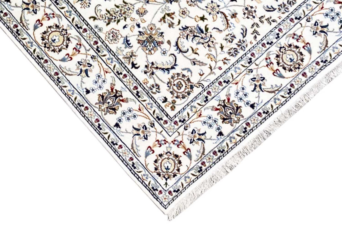 Detail of a beige rug with border, medallion, and delicate linear ornamentation