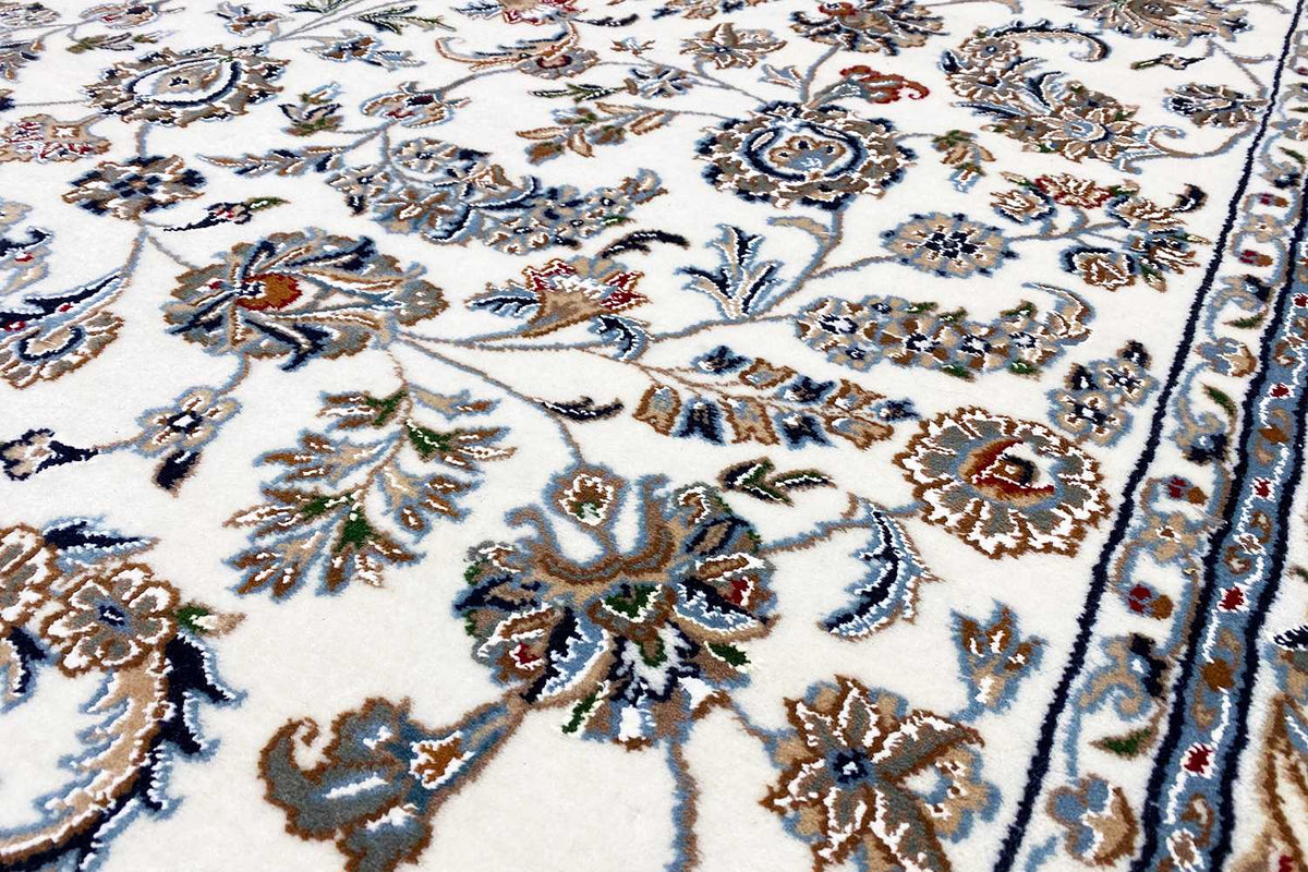Close-up: beige Oriental rug with a detailed floral pattern in blue and brown