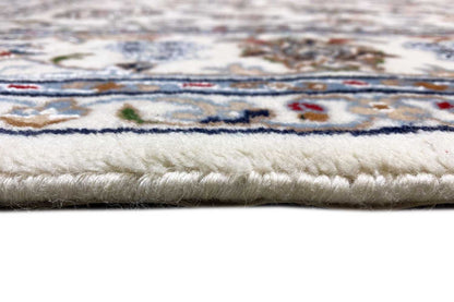 Close-up of the carpet edge: beige pile with a border and fringes