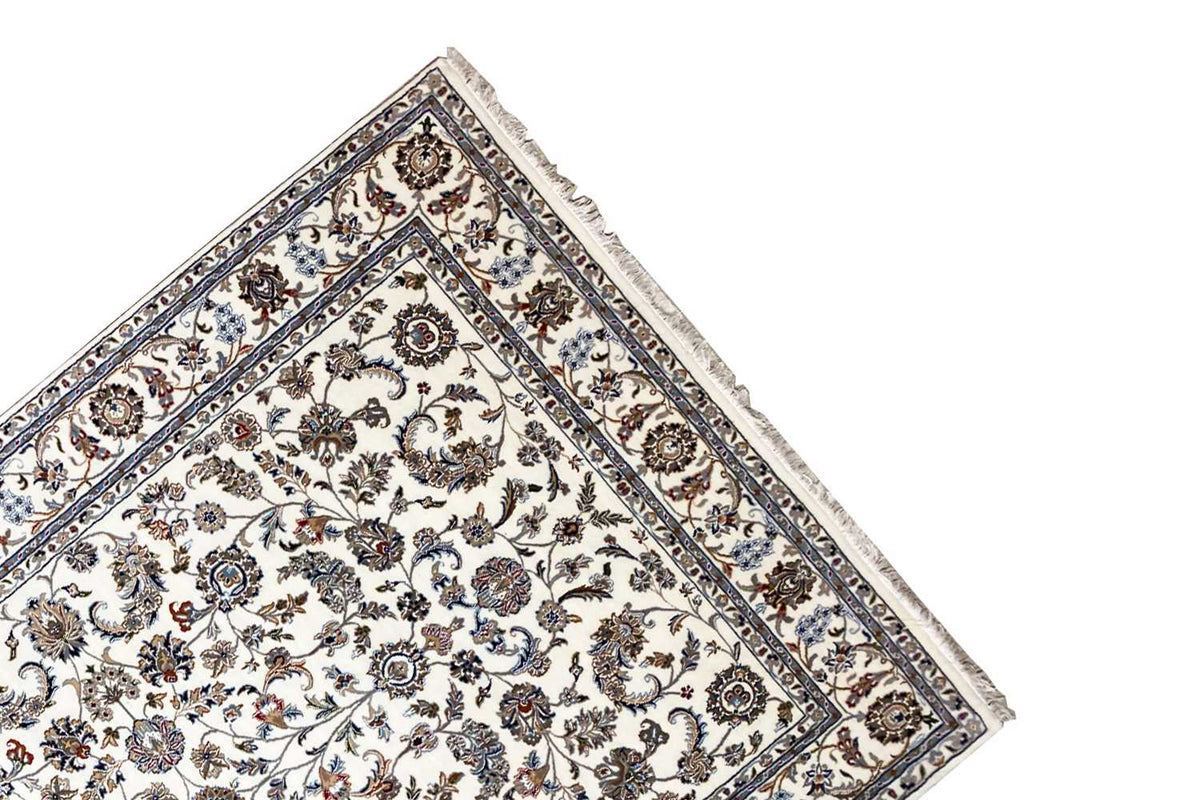Beige oriental rug in triangular view with a floral pattern and blue decorative border line