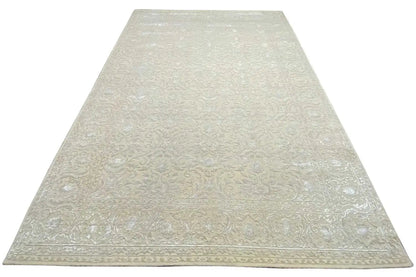 Light beige rug with an all-over damask pattern and straight edges.
