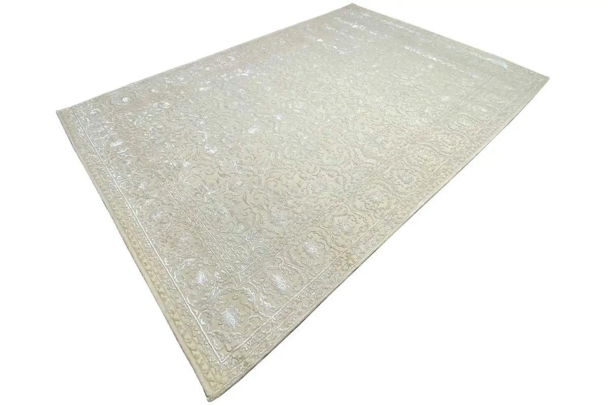 Light beige rug with finely textured damask pattern and an even pile.