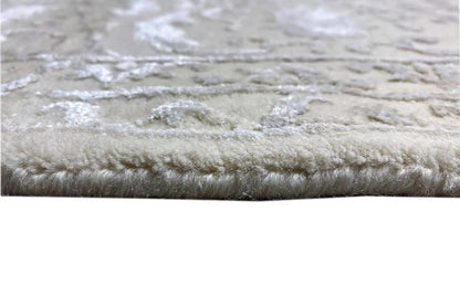 Close-up of a carpet edge with dense, short pile and a light beige relief pattern.