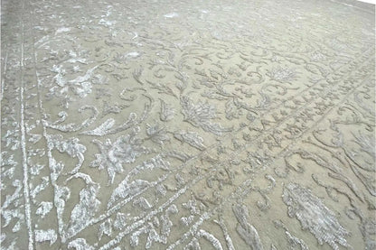 Close-up of the light beige rug with a raised pattern and speckled surface.